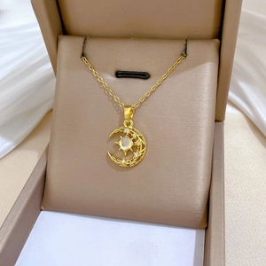 Macro view of gold hollow moon and star pendant with sparkling inlaid zircon stones