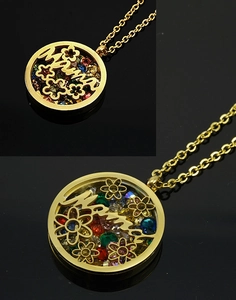 Macro detail of gold 18K plated Mama pendant with floral patterns and colorful crystals