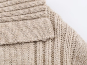 Close-up of beige ribbed knit texture and detailed stitching on warm winter sweater