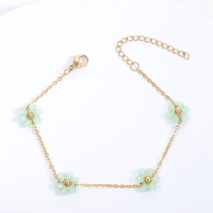 Detail of adjustable gold stainless steel bracelet with green floral resin beads
