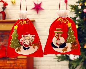 Close-up of red Christmas gift bags with 3D Santa and Snowman embroidery and drawstrings