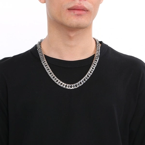 Close-up of a silver stainless steel cuban link chain worn by a male model in black shirt