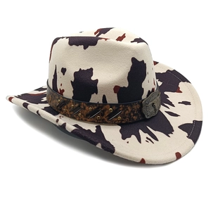Detail of cow print cowboy hat featuring leopard band and vintage metal buckle