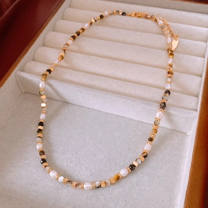 Detail of freshwater pearl and tiger eye bead necklace with lobster clasp in a jewelry box