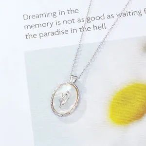 S925 sterling silver tulip mother of pearl necklace on a magazine background