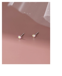 Détail macro de boucles d'oreilles en argent S999 avec zircons cubiques irisés brillants