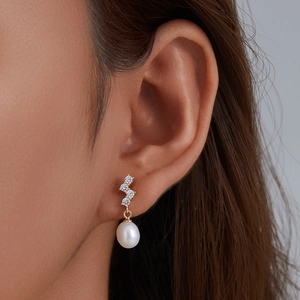Elegant gold S925 silver stud earrings with teardrop pearl and zircon on model