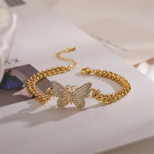 Macro shot of gold Cuban link bracelet featuring a sparkling zircon butterfly charm