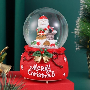 Christmas crystal ball music box with Santa Claus inside a red festive gift bag base