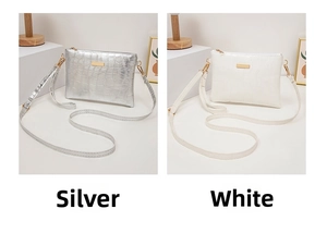 Detail view of small faux leather handbags in silver and white with crocodile pattern