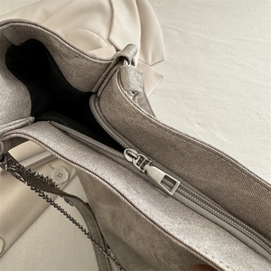 Grey textured canvas tote bag with metal zipper and silver chain strap details