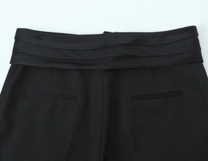 Détail du pantalon habillé noir avec taille satinée plissée et poches passepoilées