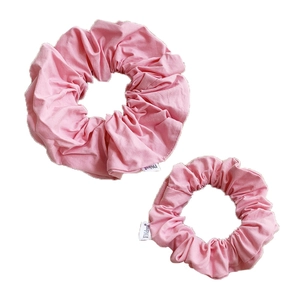 Pink fabric scrunchies set in two sizes featuring soft pleated texture on white background