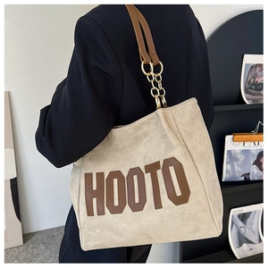 Beige faux suede oversized tote bag with HOOTO logo shown on shoulder for scale