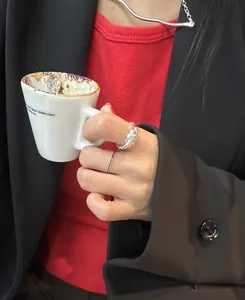 Model wearing 925 silver wave necklace and textured rings with chic black blazer
