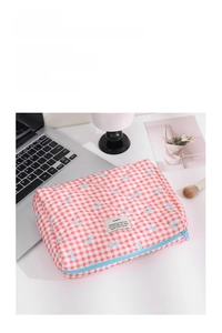 Close-up of quilted floral cosmetic bag with blue bow pattern and blue zipper detail