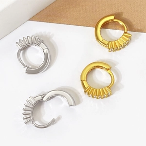 Detail of gold and silver hoop earrings with radial zircon settings and clasp mechanism