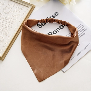 Detailed view of a brown satin headscarf bandana with an elastic band on a fashion magazine