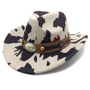 Detail of western cowboy hat featuring cow print felt and bull head engraved metal buckle