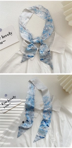 Detail of silk-like oil painting scarf with blue and white floral pattern on textured paper