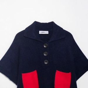 Dark blue knit vest with polo collar, large black buttons and red contrast pockets