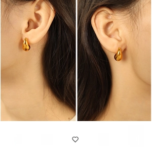Close-up of elegant polished gold teardrop earrings worn by a model in a minimalist style