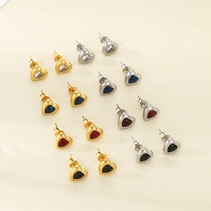 Detailed view of eight pairs of heart-shaped earrings in gold and silver settings