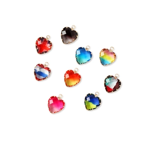 Close-up of nine faceted glass heart pendants with gold metal edges for DIY jewelry