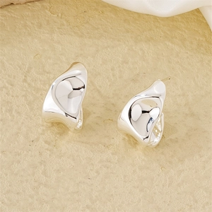 Detail shot of silver stud earrings with high-polish liquid metal texture and irregular curves