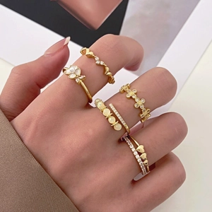 Detail of five-piece gold ring set featuring opal flowers and heart-shaped crystals