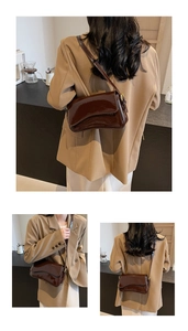Detail view of dark brown wax leather crossbody bag with adjustable strap and glossy finish