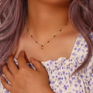 Titanium steel gold necklace featuring green beads and a shell pendant on a model