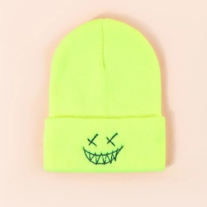 Close-up of neon green knit beanie featuring black embroidered graffiti devil face detail