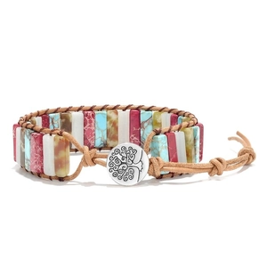Detail of bohemian woven leather bracelet with colorful stones and tree of life button