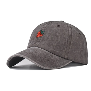 Detail showing washed grey cotton fabric and red strawberry embroidery on baseball cap