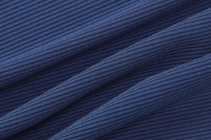Gros plan sur la texture du tricot côtelé bleu foncé montrant l'élasticité du tissu
