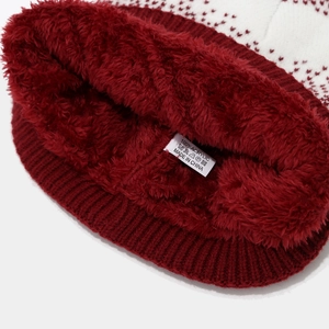 Detail of red and white knit hat showing thick maroon plush lining and washing label