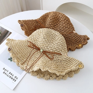 Handcrafted straw sun hats in beige and brown with daisy beads and wavy brim