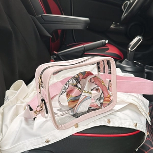 Detail of transparent PVC crossbody bag with pink trim and floral scarf inside