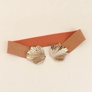 Details eines orangen elastischen Stoffgürtels mit zwei goldenen Muschelschnallen