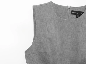 Close-up of grey satin dress neckline featuring zipper detail and branded label texture