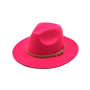 Detail of rose red fedora hat featuring brown leather band and gold metal buckle