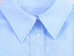 Gros plan sur le col rabattu standard et les détails des boutons d'une chemise bleu clair