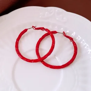 Glossy red hammered round hoop earrings with elegant texture for fashionable women