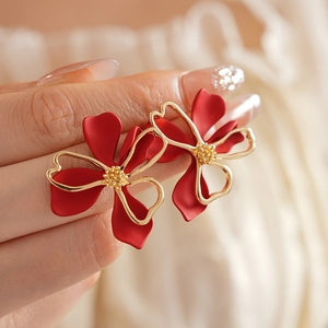 Detailed close-up of French vintage red flower earrings with elegant gold trim details