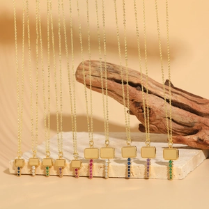 Detail of gold rectangular pendant necklaces with colorful zircon stones on stone display