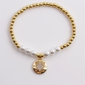 Bracelet à billes dorées avec perles blanches et un pendentif étoile boussole minimaliste