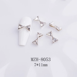 Close-up of silver metal bow nail art charm with K9 crystal rhinestone, size 7x11mm