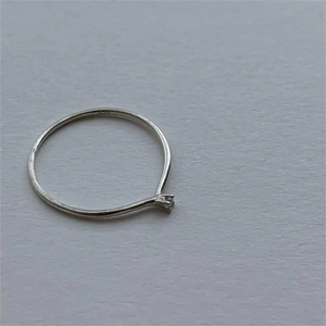 Minimalist 925 sterling silver ring with single zircon stone on a white background