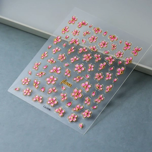 Détails macro de stickers ongles cerisiers 3D avec bordures dorées gaufrées